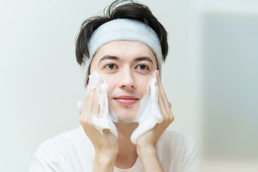 Asian young man washing his face