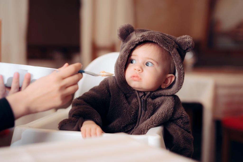 Small infant being a picky eater disliking the food