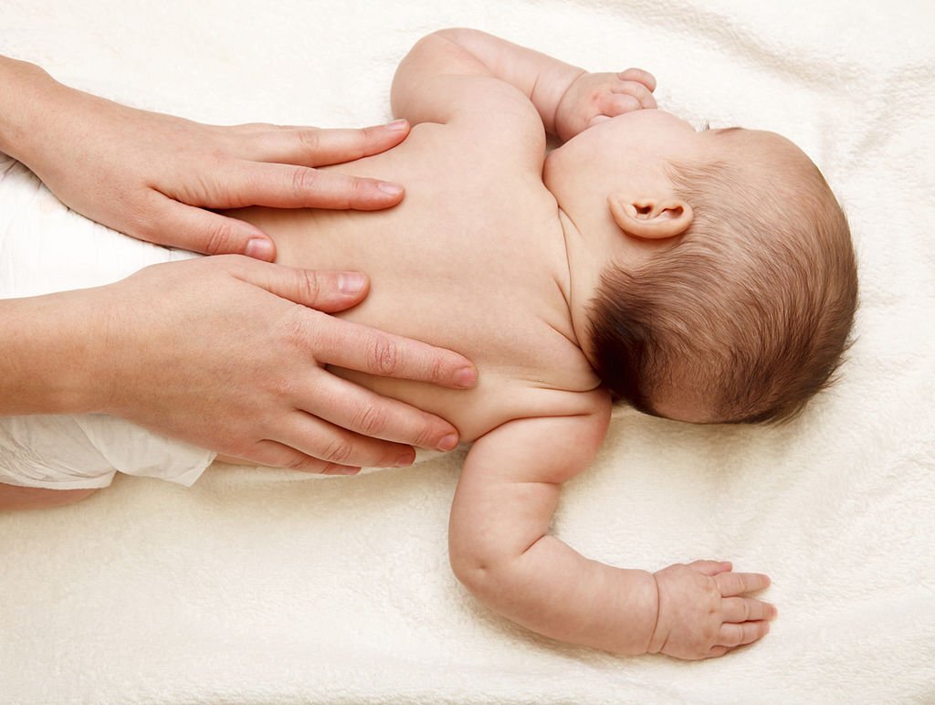 Masseuse massaging 5 months infant
