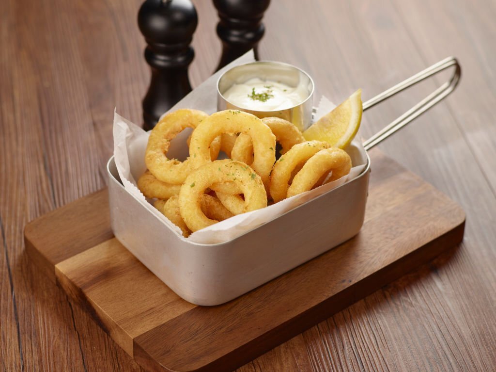 Calamari Ring with dip and lemon in a dish isolated on dark wooden table side view singapore food