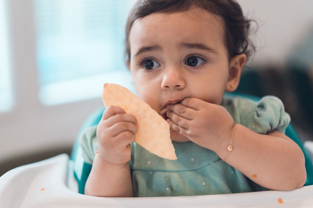 Toddler eating cracker.