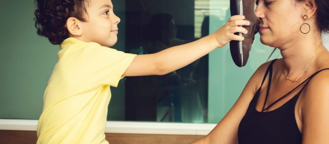 Son showing his shoe to his mother, and she don't like the smell.