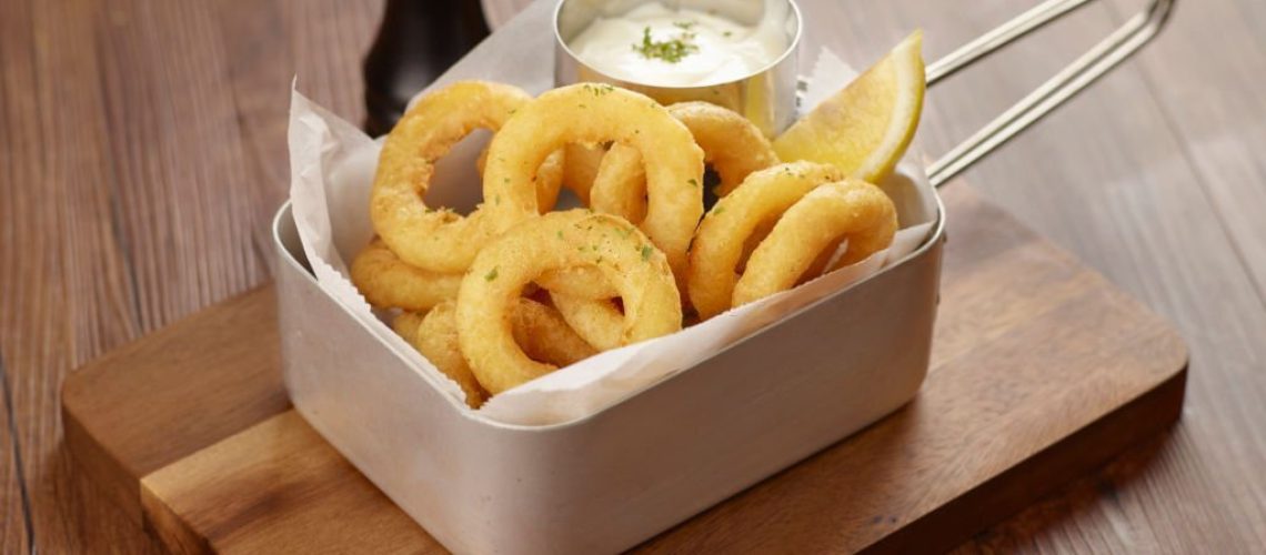 Calamari Ring with dip and lemon in a dish isolated on dark wooden table side view singapore food