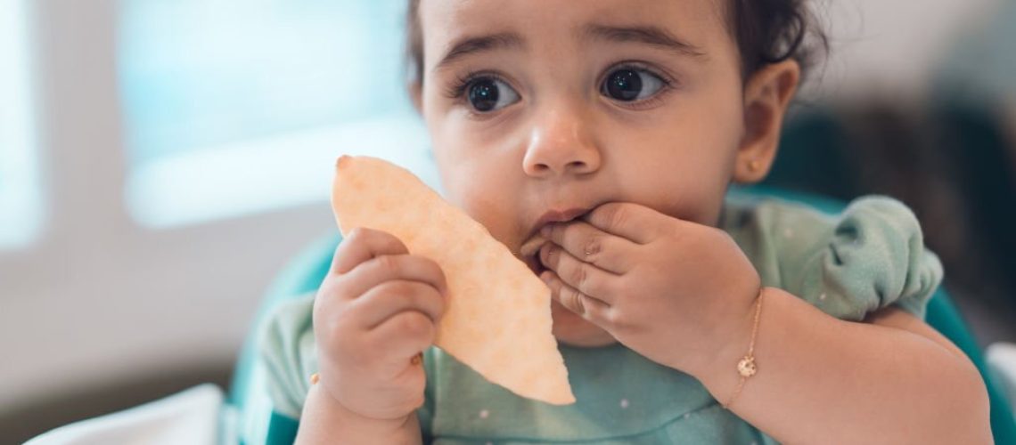 Toddler eating cracker.