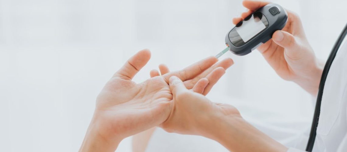 Doctor use glucosmeter checking blood sugar level from patient hand